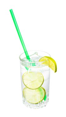 Cin ve tonik karışımı beyaz arka planda izole edilmiş limon, buz ve yeşil plastik kamış dilimleri ile bardakta.