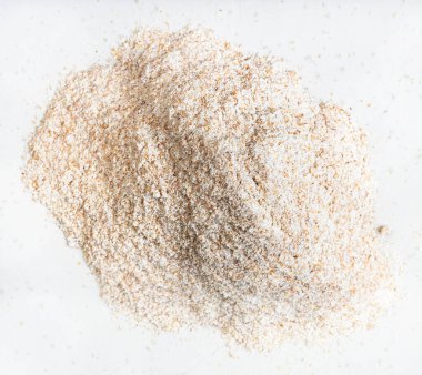 Tam tahıllı buğday un yığınının üst görüntüsü gri seramik tabağa yakın.