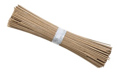 Beyaz arka planda izole edilmiş karabuğday unundan bir avuç kurutulmuş soba eriştesi.