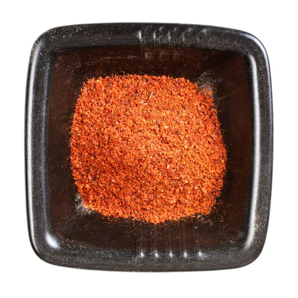 白色背景隔离的黑碗中红辣椒粉的顶部视图 — 图库照片