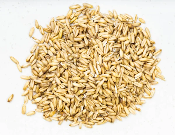 Cilalanmamış yulaf taneciklerinin üst görüntüsü gri seramik tabağa yakın