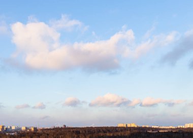 Pofuduk bulutlar mavi günbatımında gökyüzü ilkbahar akşamında şehir parkında