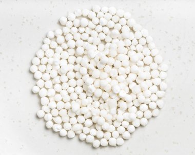 Gri seramik tabakta kuru sabudana (tapioca sago) yığını