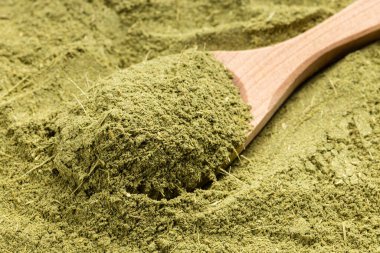 Değirmenli stevia rebaudiana bitkisi (doğal şeker ikamesi) ile ahşap kaşık görünümünün üzerinde şeker yığını üzerine yakın çekim