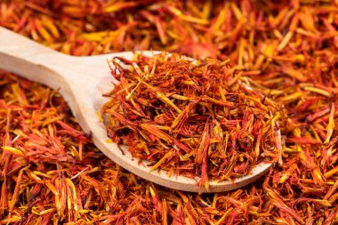 Kurumuş safran yapraklar kurumuş çiçek yığınının üzerinde tahta kaşıkla kapanır.