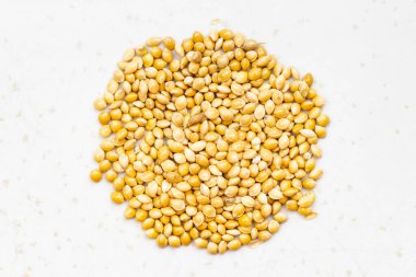 Cilalanmamış sarı proso darı yığınının üst görüntüsü gri seramik tabağa yakın