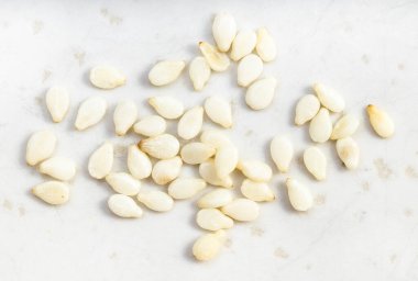 Bazı beyaz susam tohumları gri seramik tabakta kapanıyor.