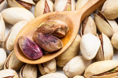 Olgun fıstıklı kabuklu ahşap kaşık. Yaklaş.