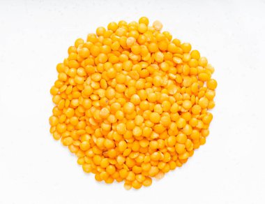 Ham kırmızı mercimek yığınının üst görüntüsü gri seramik tabakta kapanıyor.