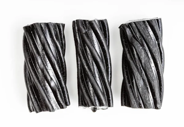 Few Coiled Black Licorice Candies White Plate — Stock Photo, Image