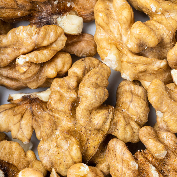 square food background - shelled walnuts close up