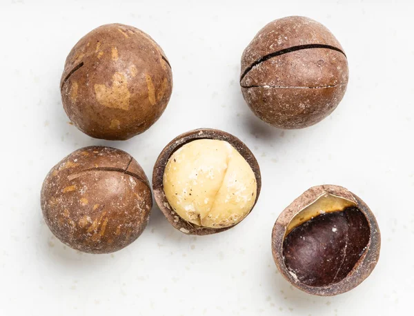 Poche Noci Macadamia Segate Sgusciate Vicino Piatto Ceramica Grigia — Foto Stock