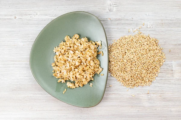 Top View Raw Whole Oat Grains Boiled Porridge Green Plate — Stock Photo, Image