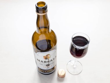 MOSCOW, RUSSIA - JUNE 10, 2021: wine glass and open bottle of sweet Marsala from Cantine Intorcia. Marsala is fortified wine produced in Marsala city area in Sicily, Italy from 1773