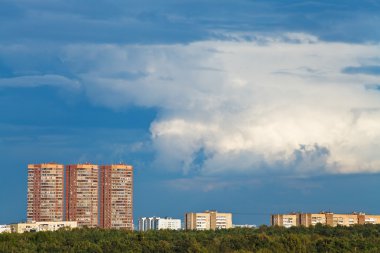 Çok öykülü evler üzerinde koyu mavi yağmurlu bulutlar