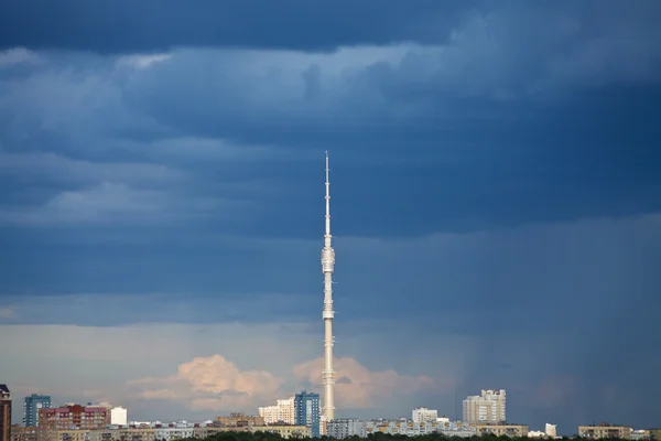 Donker blauwe regen wolken boven tv-toren — Stockfoto