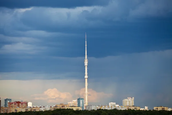 Donker blauwe regenwolken boven tv-toren in de zomer — Stockfoto