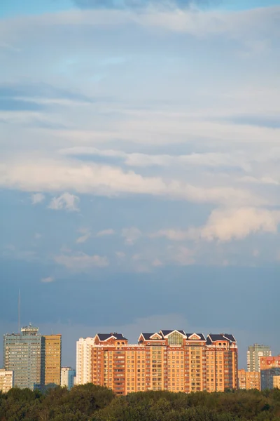 Pink and blue clouds over urban district — Stock Photo, Image