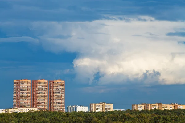 Dark blue rainy clouds over multistory houses — Stock Photo, Image