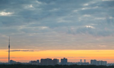 gri bulutlar ve şehir üzerinde sarı gündoğumu gökyüzü