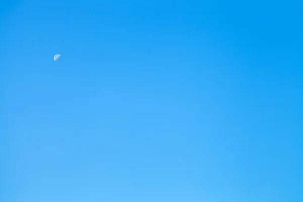 Metade branca da lua no céu azul claro — Fotografia de Stock