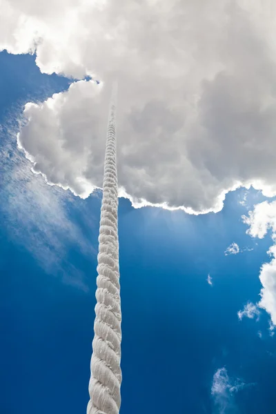 Tightrope rises to clouds in dark sky — Stock Photo, Image