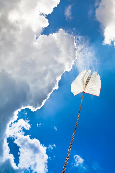 Book tied on chain soars into dark sky — Stock Photo, Image