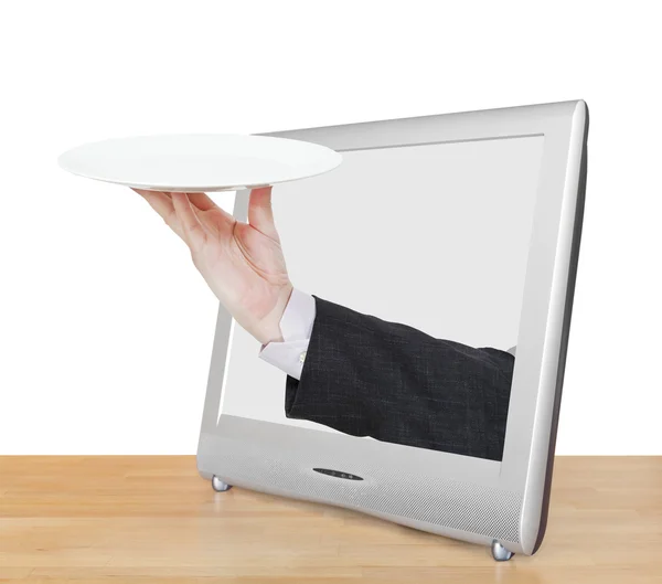 Hand with empty white plate leans out TV screen — Stock Photo, Image