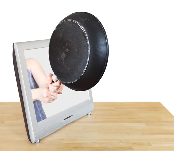 Woman with frying pan leans out TV screen — Stock Photo, Image