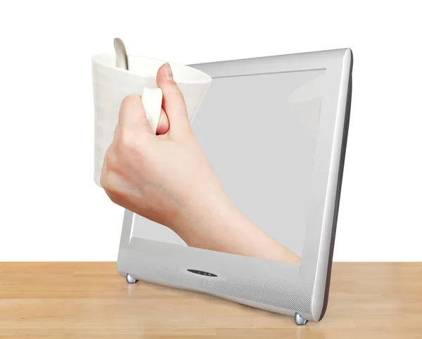 White mug in hand leans out TV screen — Stock Photo, Image