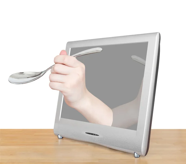 Hand with soup spoon leans out TV screen — Stock Photo, Image