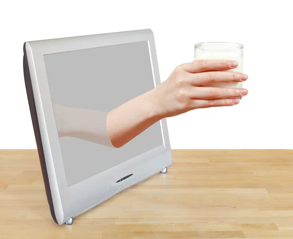 Mano celebración vaso de leche inclina la pantalla de televisión — Foto de Stock