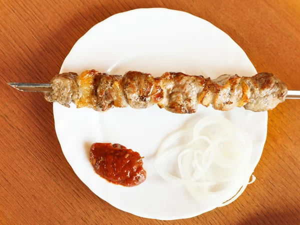 Pohled shora shishkebab jehněčí špíz na bílé desce — Stock fotografie