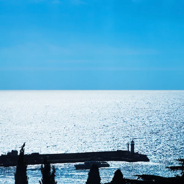 Pier mit Leuchtturm in der Stadt Jalta am blauen Abend — Stockfoto