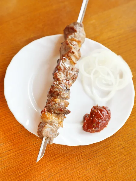 Skewer of lamb shish kebab on white plate — Stock Photo, Image