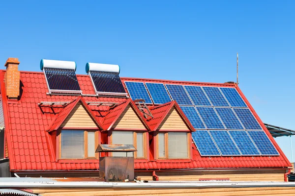 Solar Batteries and heaters on home roof — Stock Photo, Image