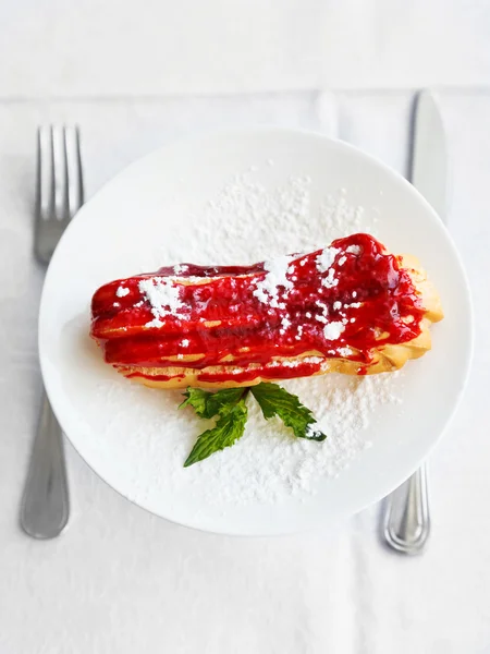 Dessert eclair on white plate — Stock Photo, Image