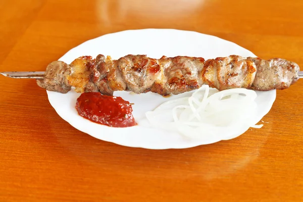 Skewer of lamb shishkebab on white plate — Stock Photo, Image