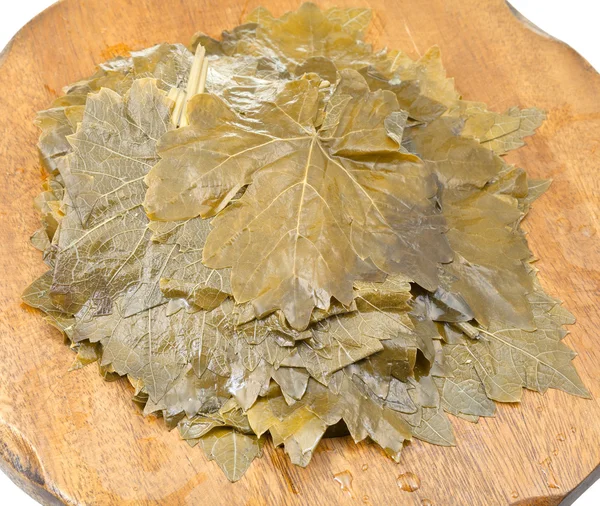 Hojas de uva en escabeche sobre tabla de madera de cerca —  Fotos de Stock