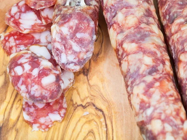 Salchicha en rodajas en tablero de madera de cerca — Foto de Stock