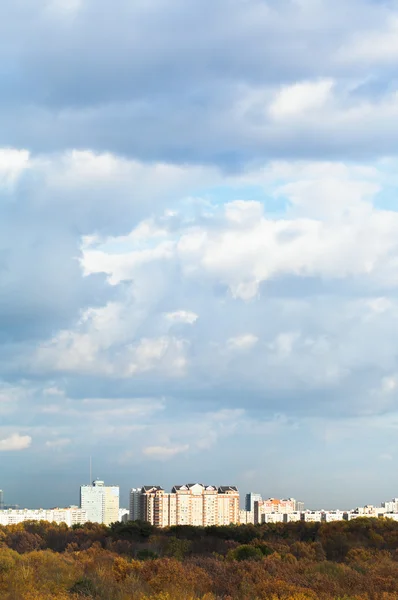 Blue clouds over urban houses on horizon — Stock Photo, Image