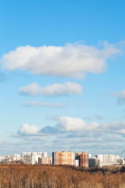 Weiße Wolken am blauen Himmel über Häusern am Herbsttag — Stockfoto