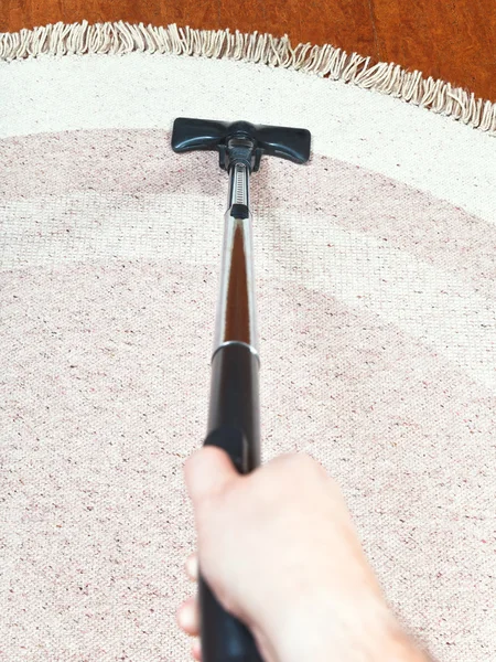 Hombre limpia una alfombra con aspiradora —  Fotos de Stock