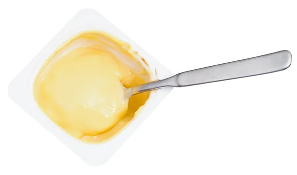 Карамельний йогурт і ложка в пластиковій чашці — стокове фото
