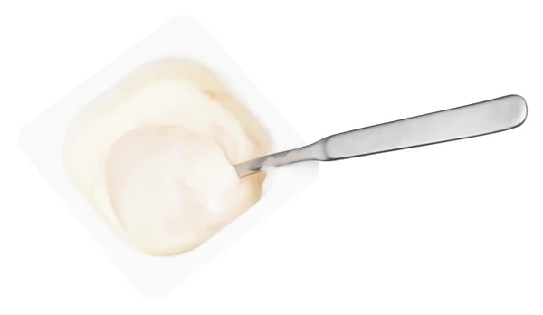 Creamy yogurt and spoon in disposable plastic cup — Stock Photo, Image