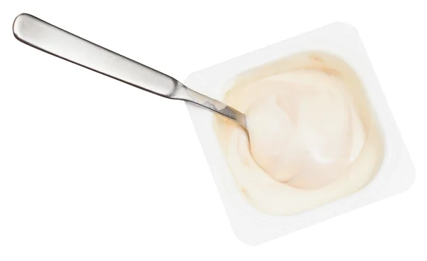 Creamy yoghurt and spoon in disposable plastic cup — Stock Photo, Image