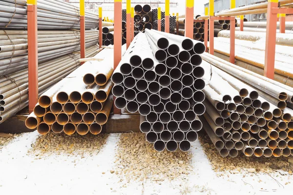 Piles of metal pipes in outdoor warehouse — Stock Photo, Image