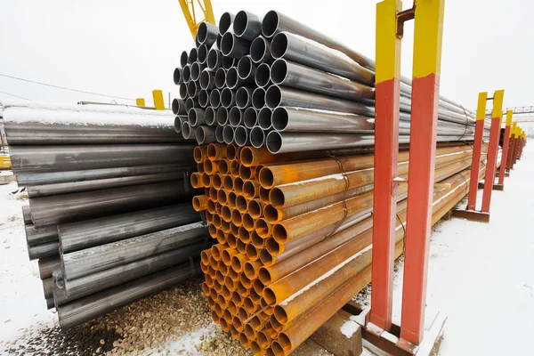 Pile of construction pipes in outdoor warehouse — Stock Photo, Image