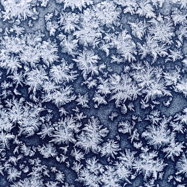 Flocos de neve e geada em vidro congelado janela — Fotografia de Stock