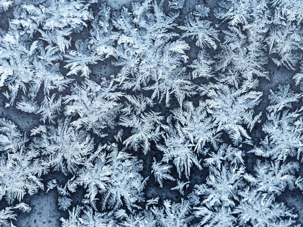 Schneeflocken und Frost auf der Fensterscheibe aus nächster Nähe — Stockfoto